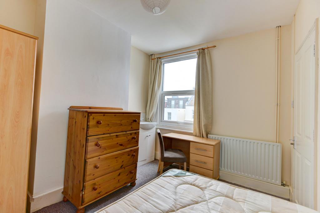 Bright, simply furnished bedroom with a double ...