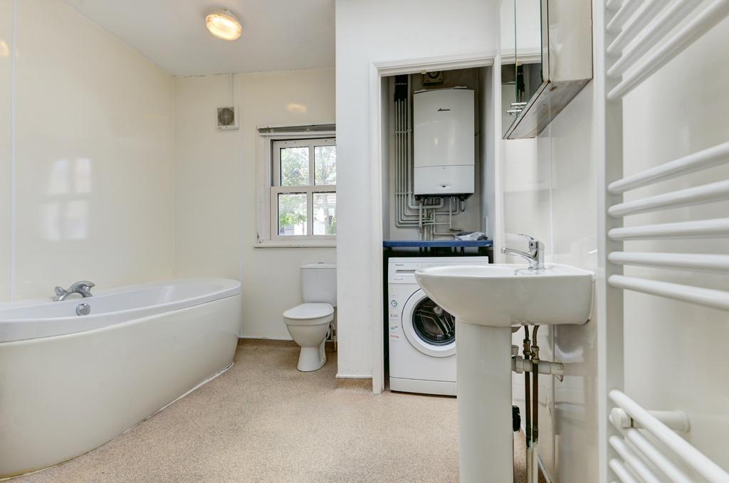 Bright, modern bathroom featuring a bathtub, se...