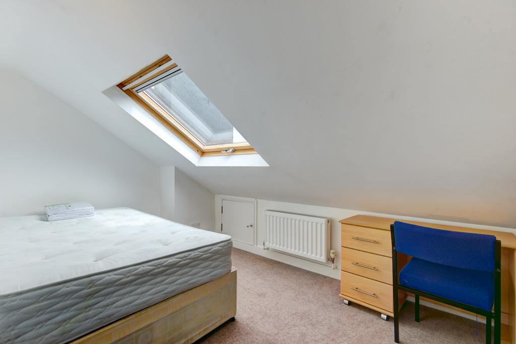 Bright attic bedroom with a double bed under a ...