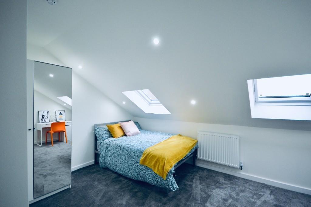 Bright and modern bedroom featuring a comfortab...