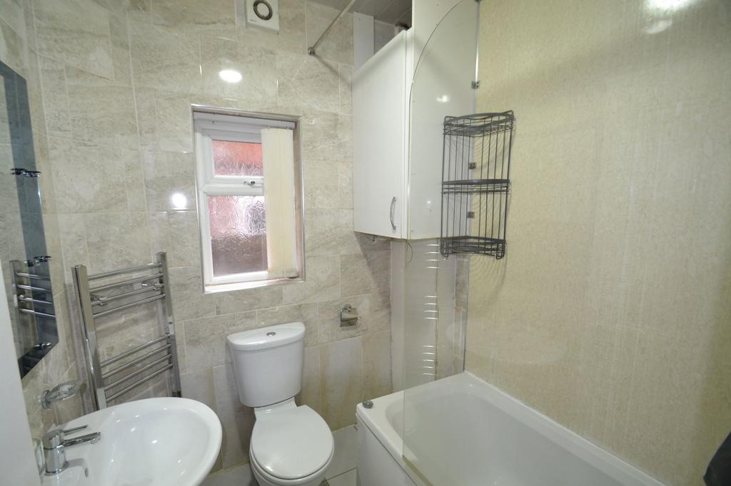 A compact bathroom featuring a toilet, bathtub,...
