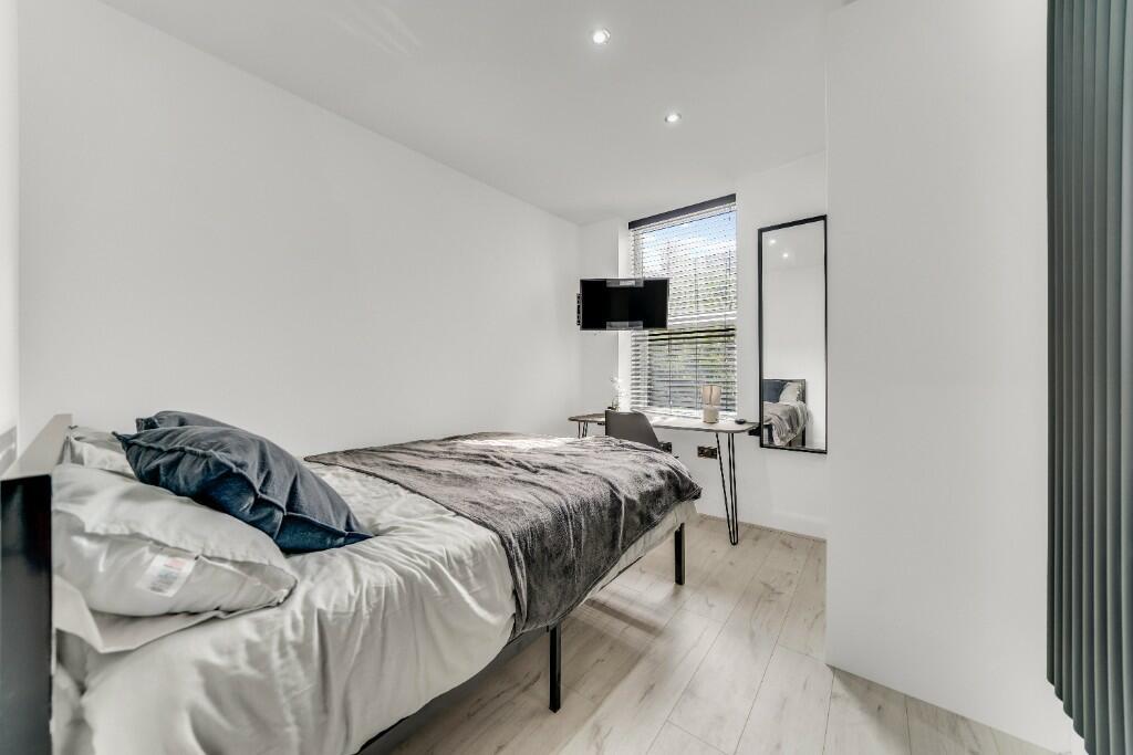 A bright and tidy single bedroom featuring a co...