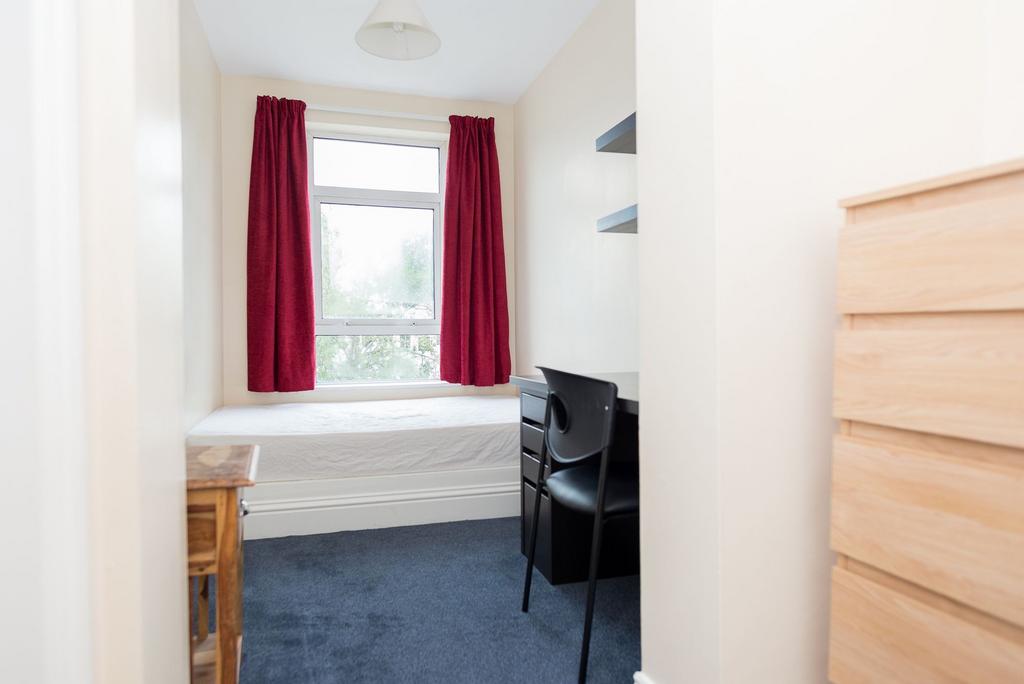Bright, simply furnished bedroom with a large w...