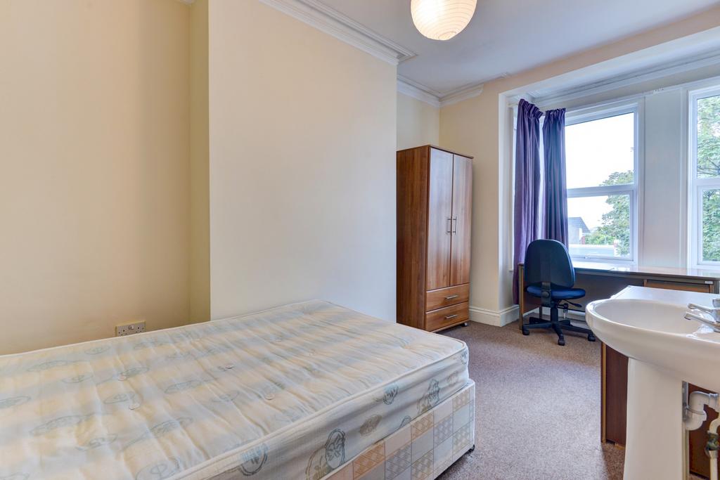Bright, simply furnished bedroom with a large w...