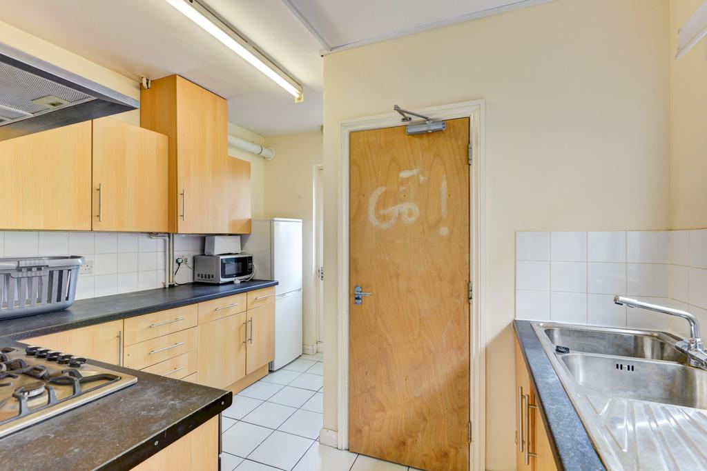 Bright galley kitchen with light wood cabinetry...