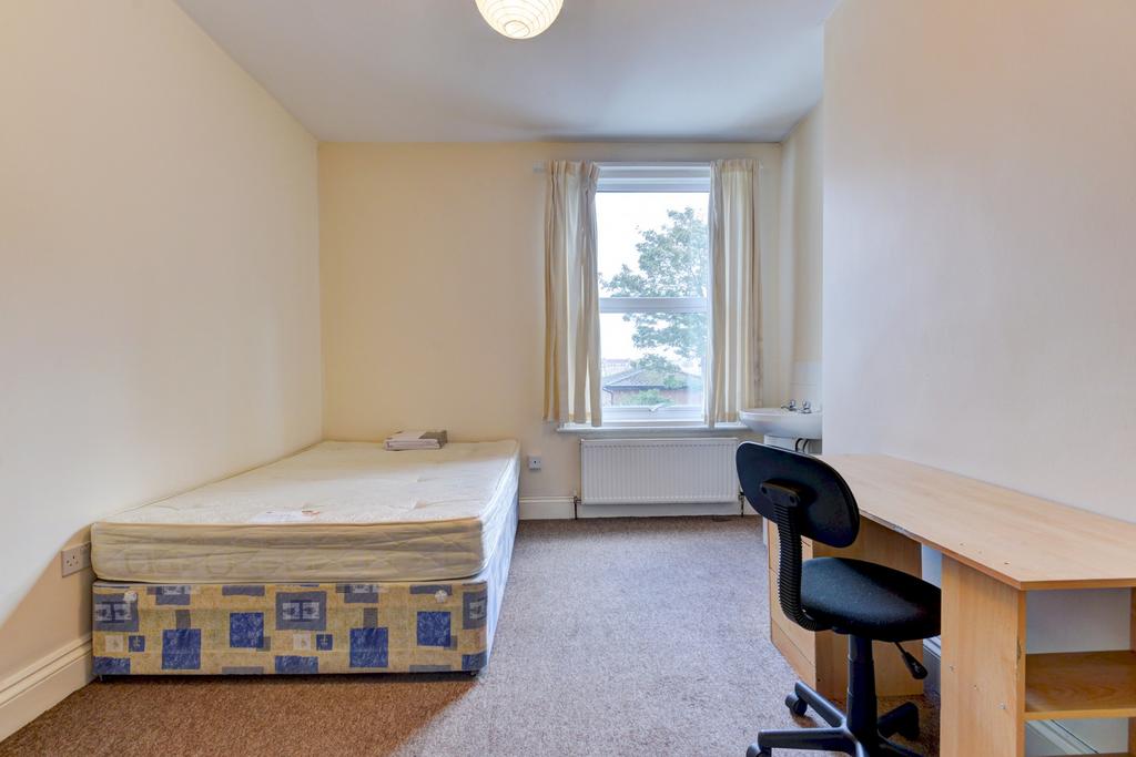 Bright, simply furnished bedroom with a single ...