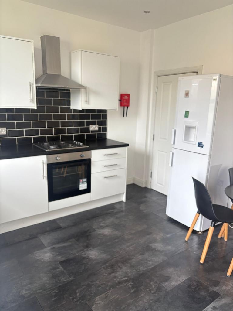 Bright modern kitchen with white cabinets, blac...