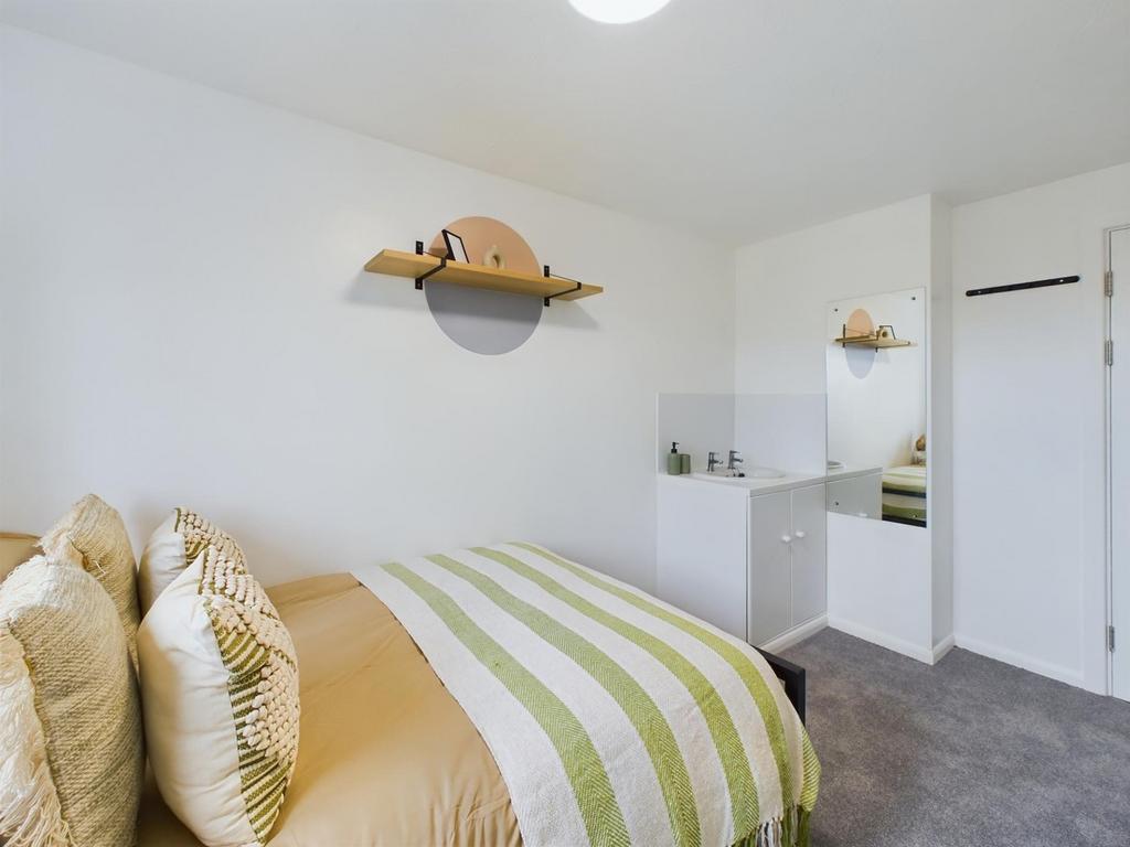 A bright and tidy double bedroom featuring mode...