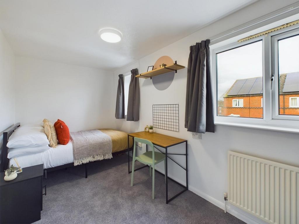A bright and clean double bedroom featuring a c...