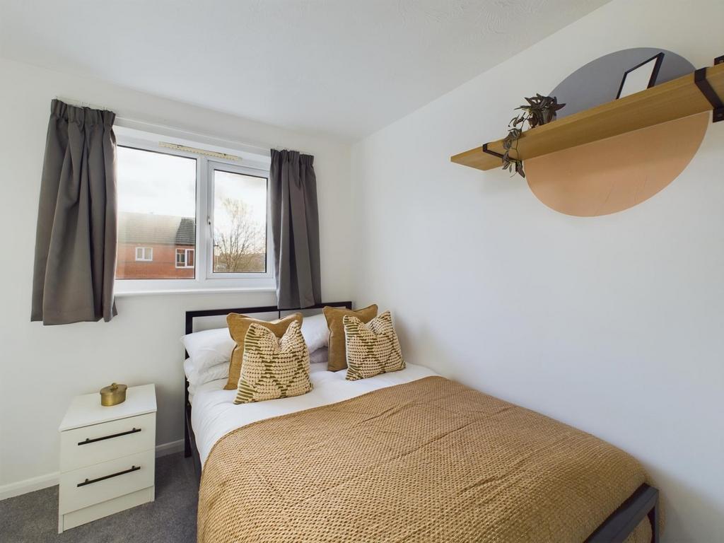 A bright and inviting double bedroom with styli...