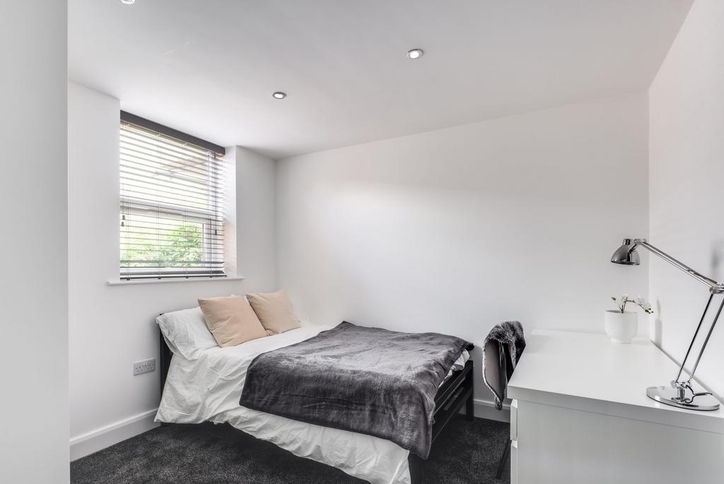 Bright and modern master bedroom featuring a co...