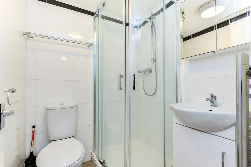 Bright, modern bathroom with a corner glass sho...