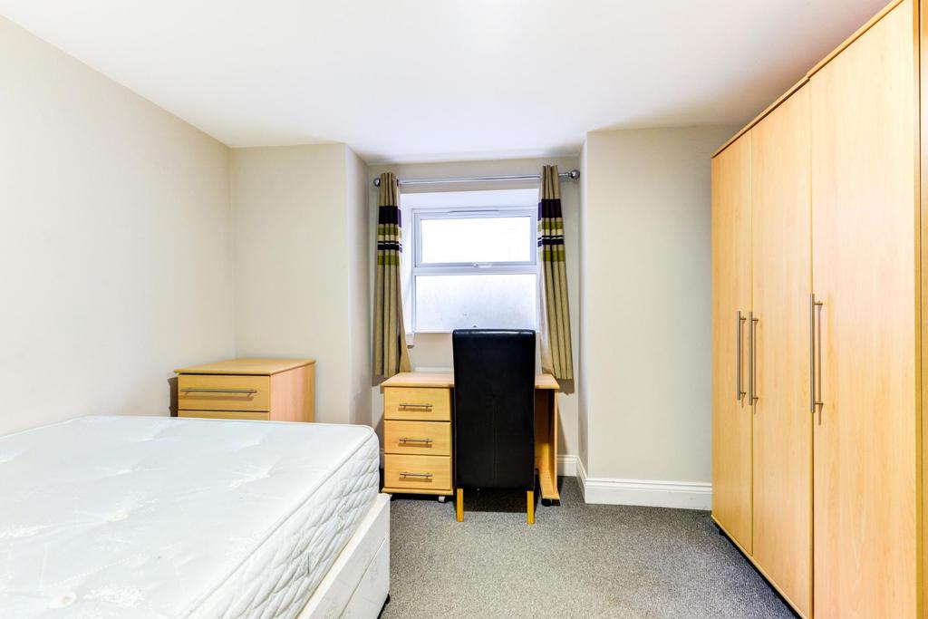 Bright, neutrally decorated bedroom with a larg...