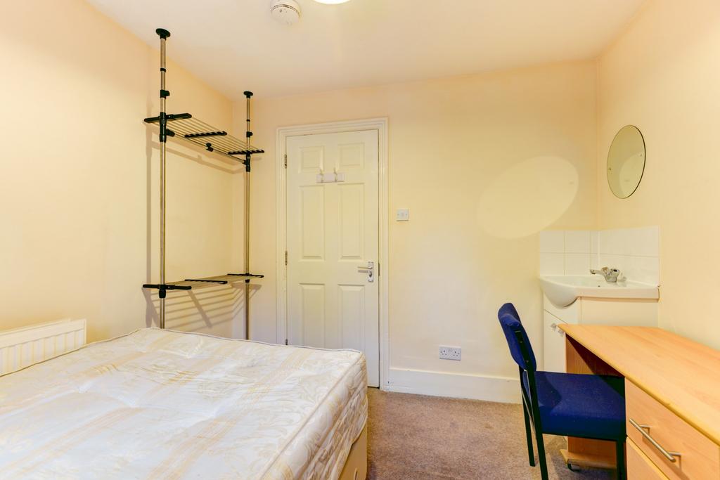 A bright and welcoming bedroom featuring a comf...