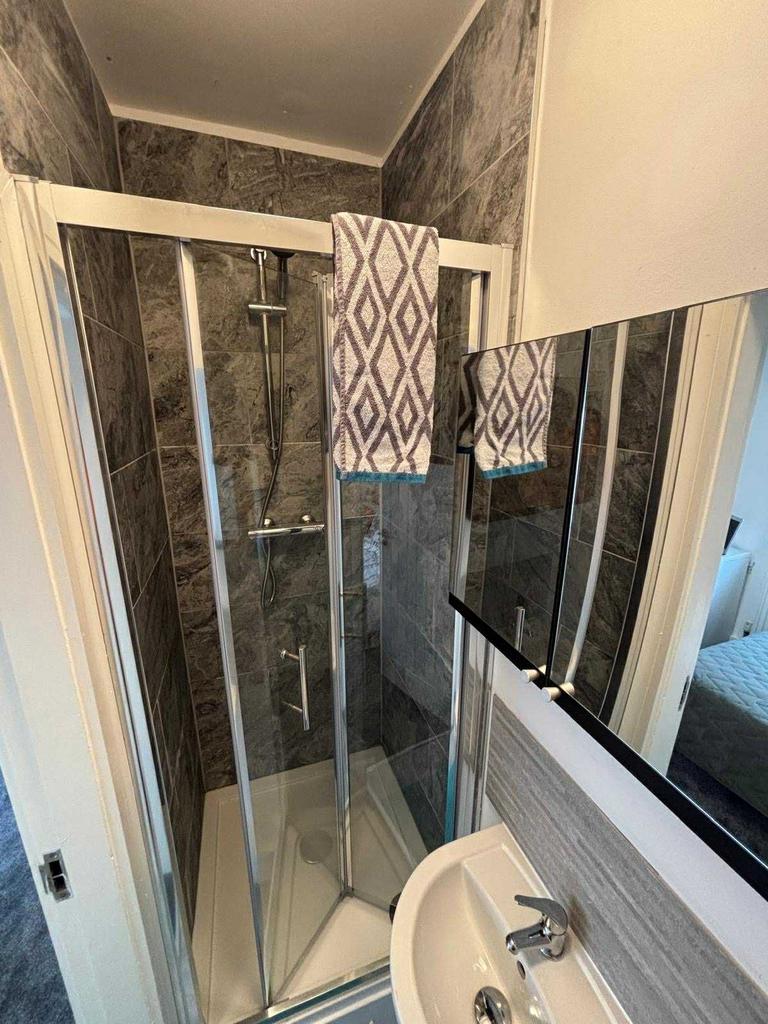 A modern bathroom featuring a glass-enclosed sh...