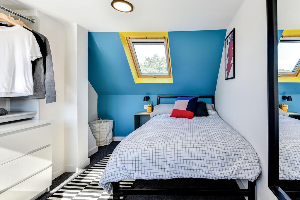 This cozy double bedroom features vibrant wall ...