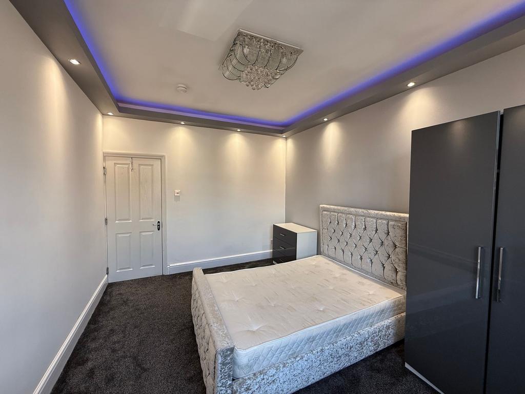 Bright, modern double bedroom with a plush upho...