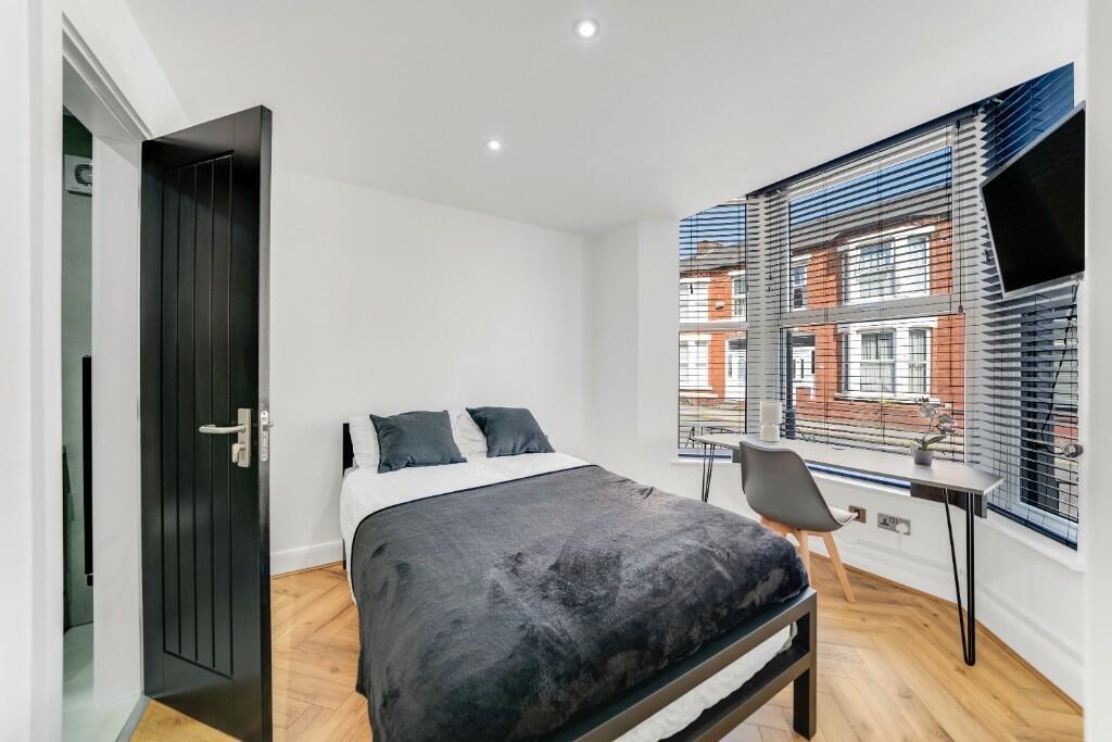 A spacious and well-lit master bedroom featurin...