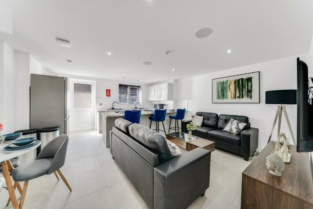 A spacious, modern living room filled with natu...