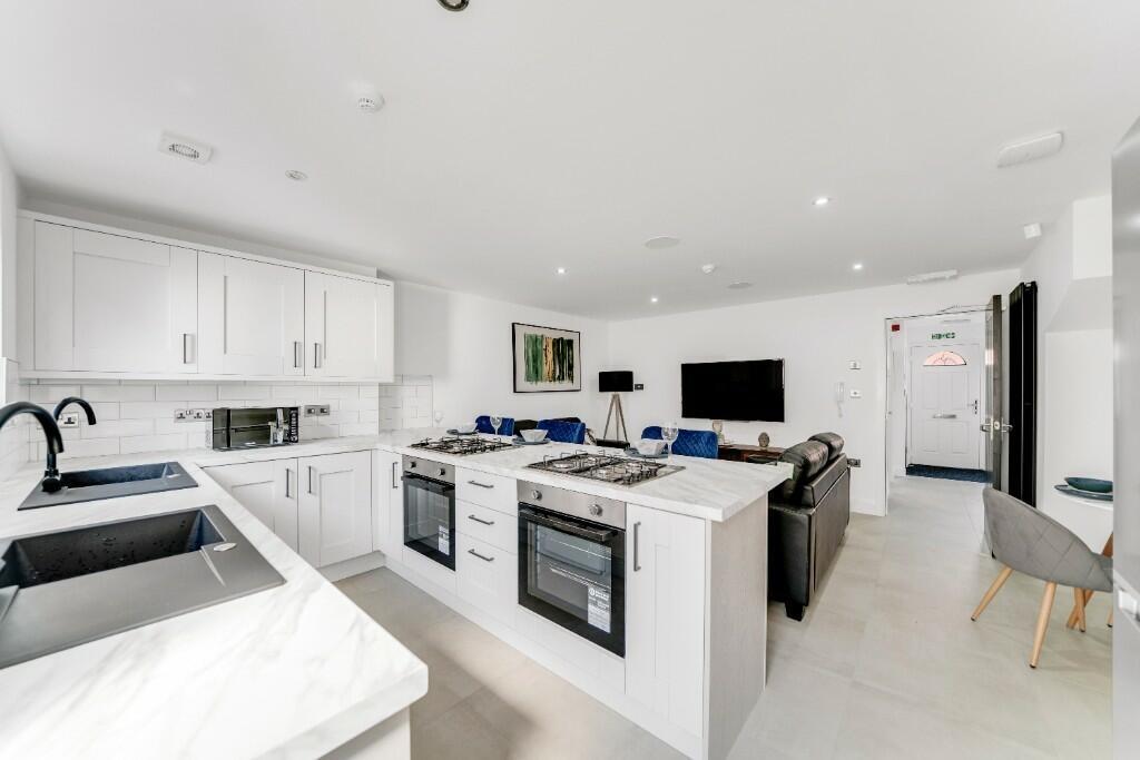 Bright and modern kitchen featuring white cabin...