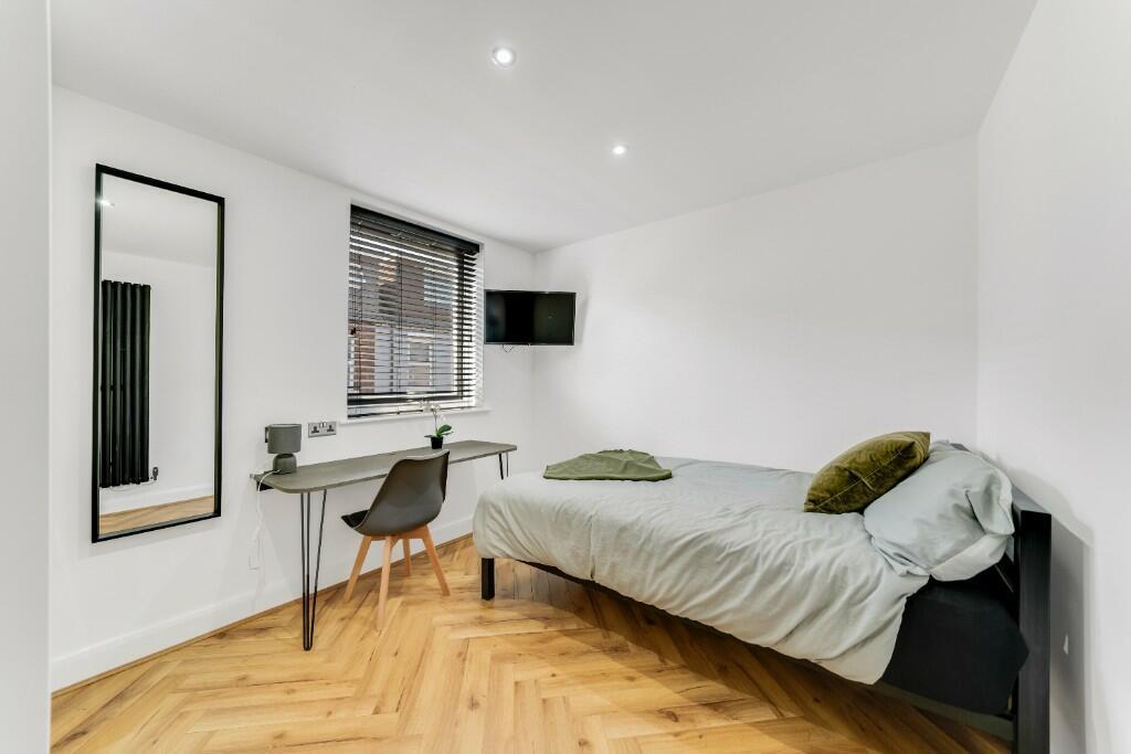 A bright and modern bedroom featuring fresh whi...