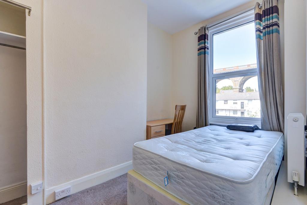 Bright single bedroom featuring a comfortable m...