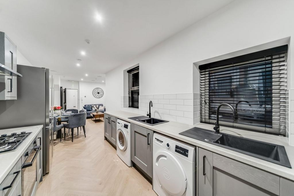 Modern, well-lit kitchen featuring twin sinks, ...