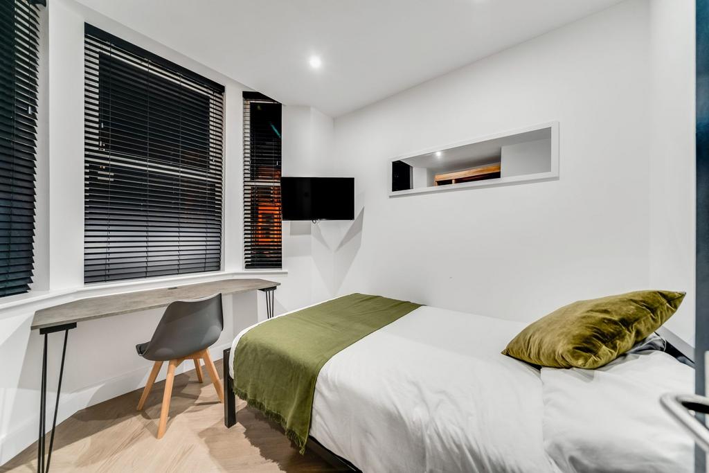 A modern single bedroom featuring a large windo...