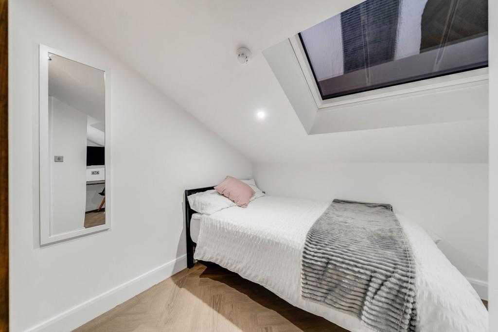 Bright and cozy bedroom with a spacious bed, so...