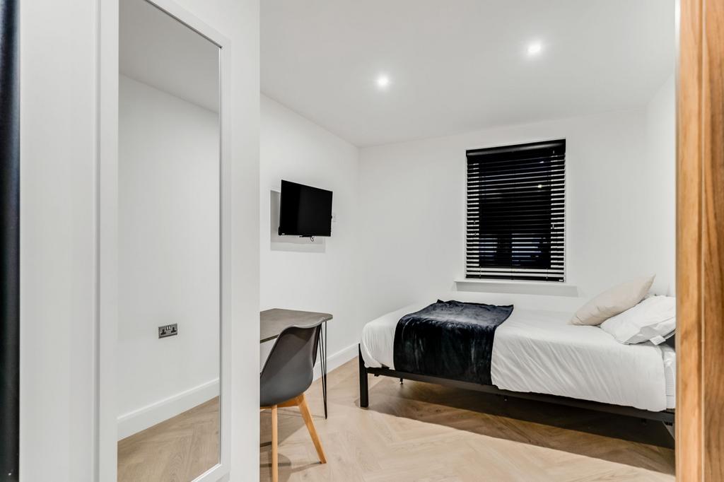A modern, neatly maintained bedroom featuring a...