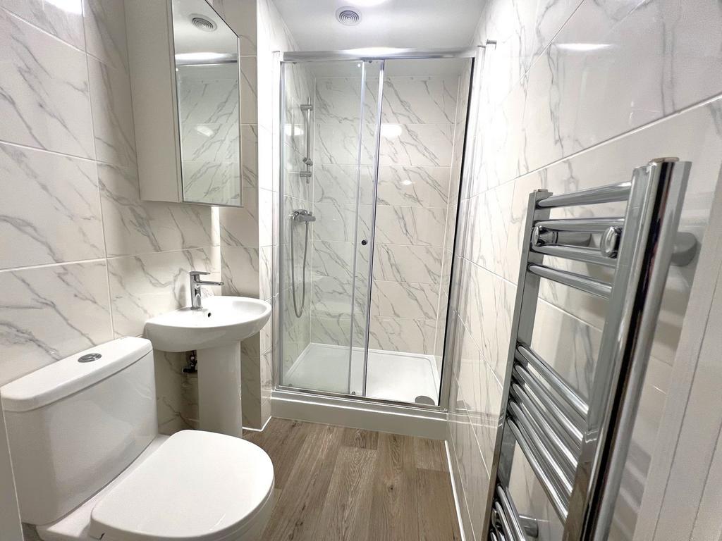 Bright, modern bathroom with a tiled walk-in sh...