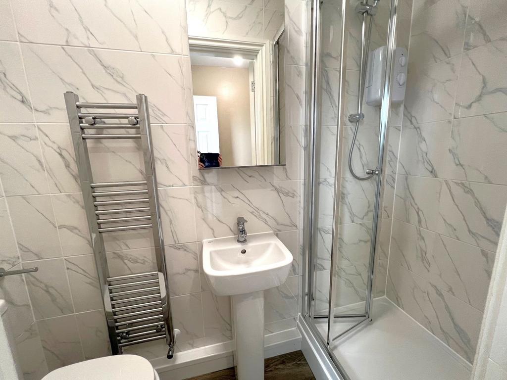 Modern tiled bathroom with a glass-fronted show...