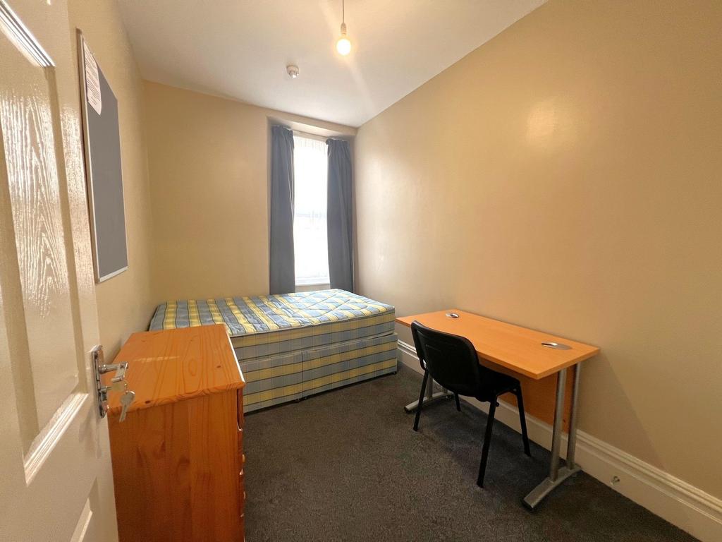 Neat single bedroom with a fitted mattress on a...