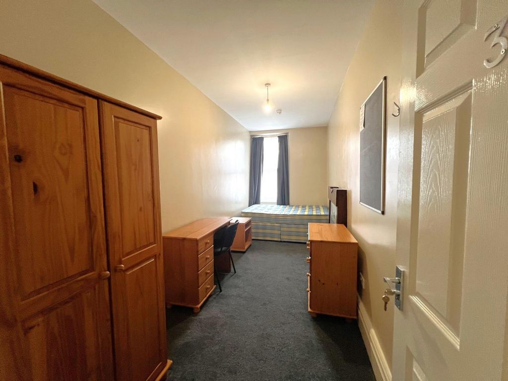 Long, neatly presented single bedroom with a la...