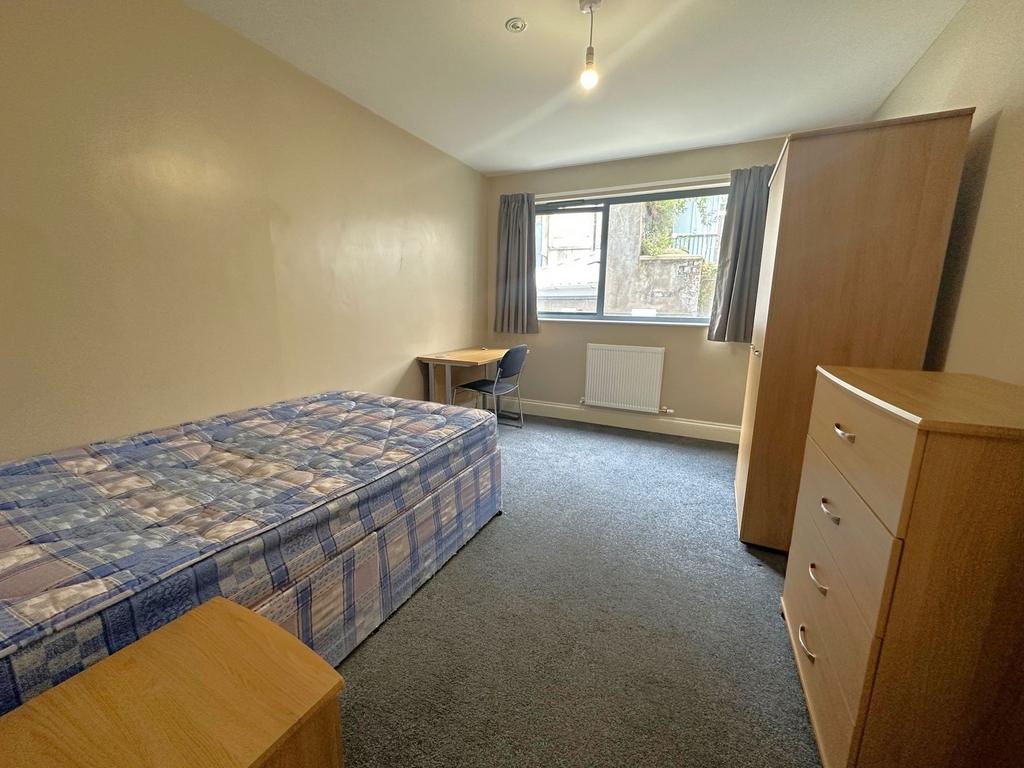 Bright single bedroom with a large window, simp...