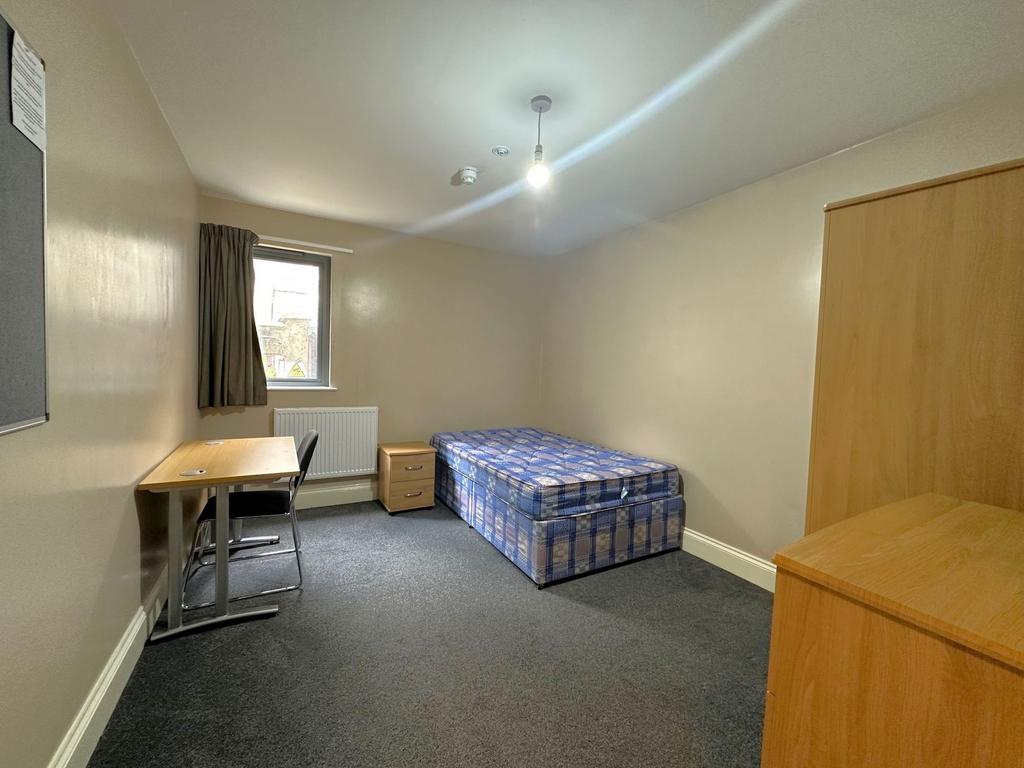 Bright, simply furnished single bedroom with a ...