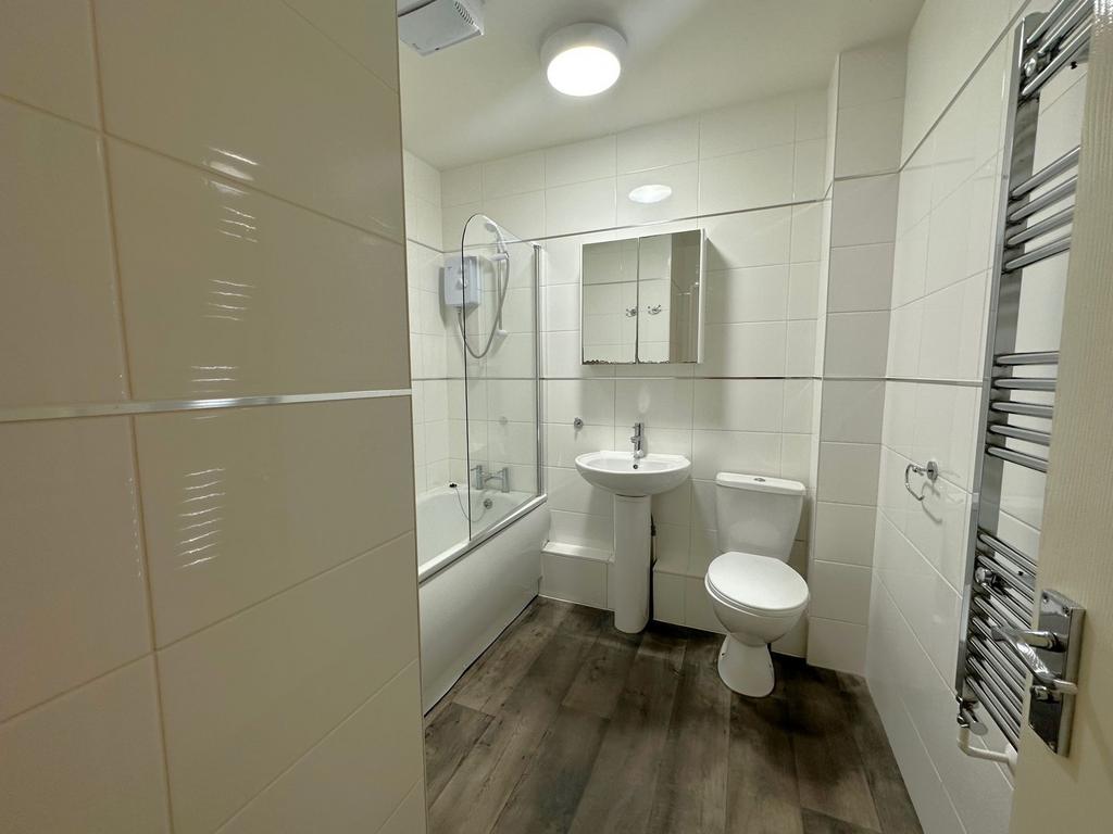 Bright, modern bathroom with a bathtub and show...