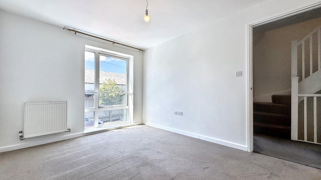 Bright, neutral living room with large glazed d...