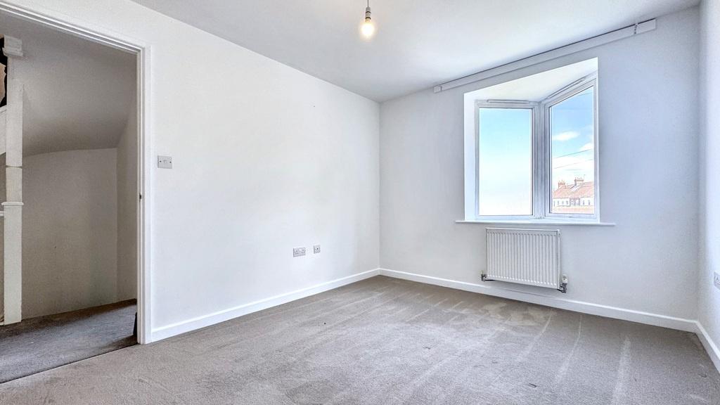 Bright, neutrally decorated double bedroom with...