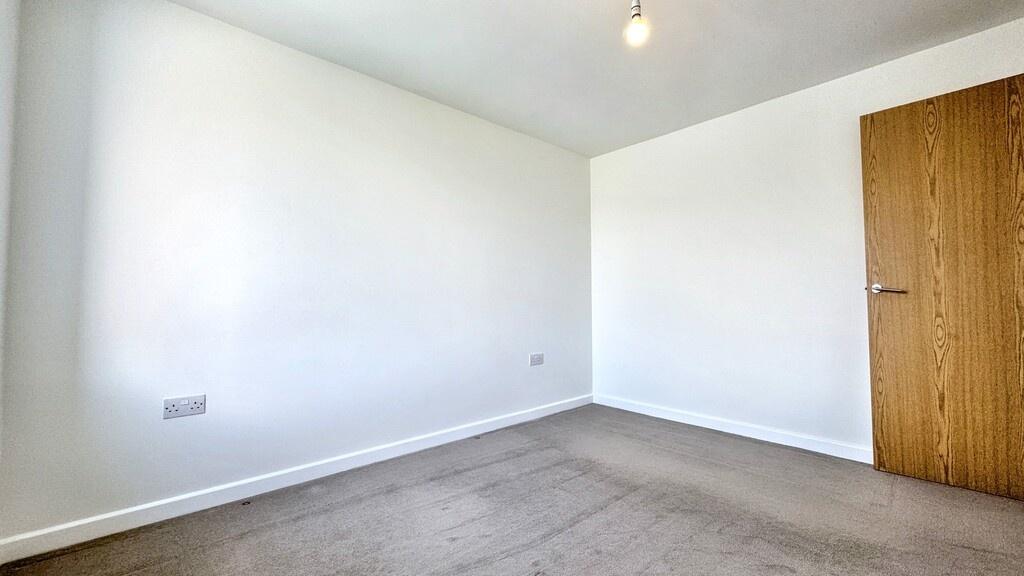 Bright, neutral double bedroom with fresh white...