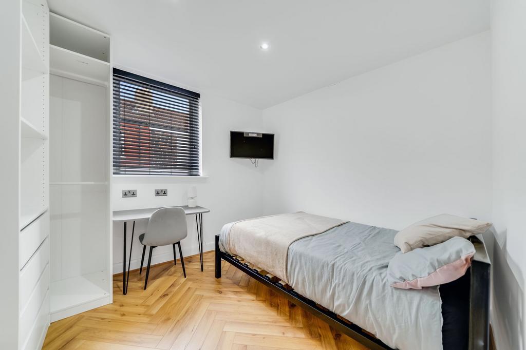 Bright and clean bedroom featuring a single bed...