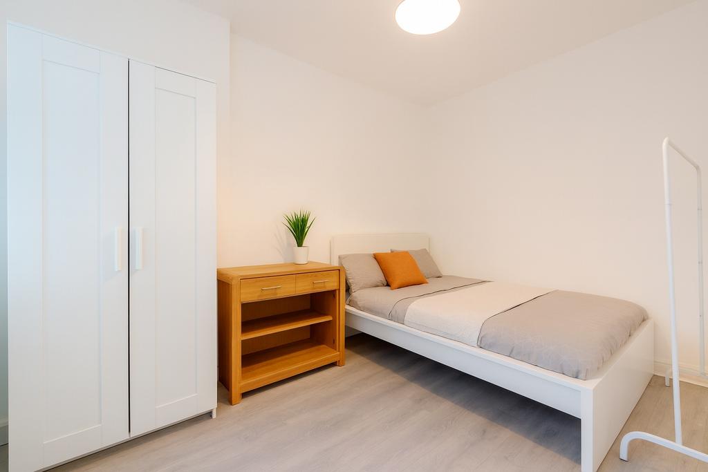 A bright and tidy single bedroom featuring a wh...