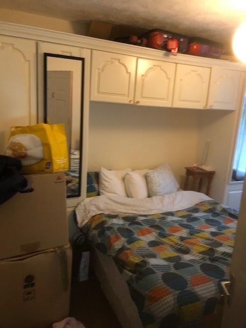 Cozy double bedroom with built-in overhead stor...
