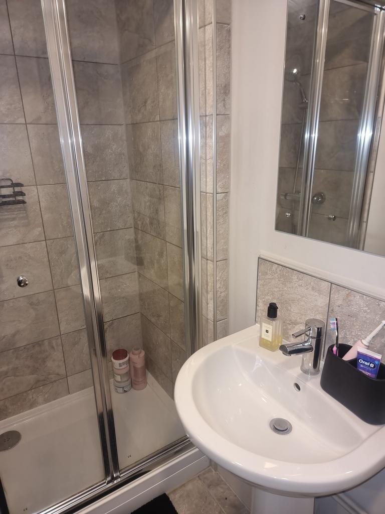 Clean, modern bathroom with a tiled walk-in sho...
