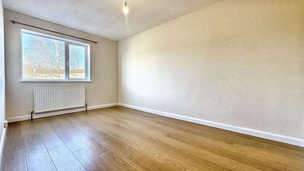 Bright, unfurnished bedroom with a large window...