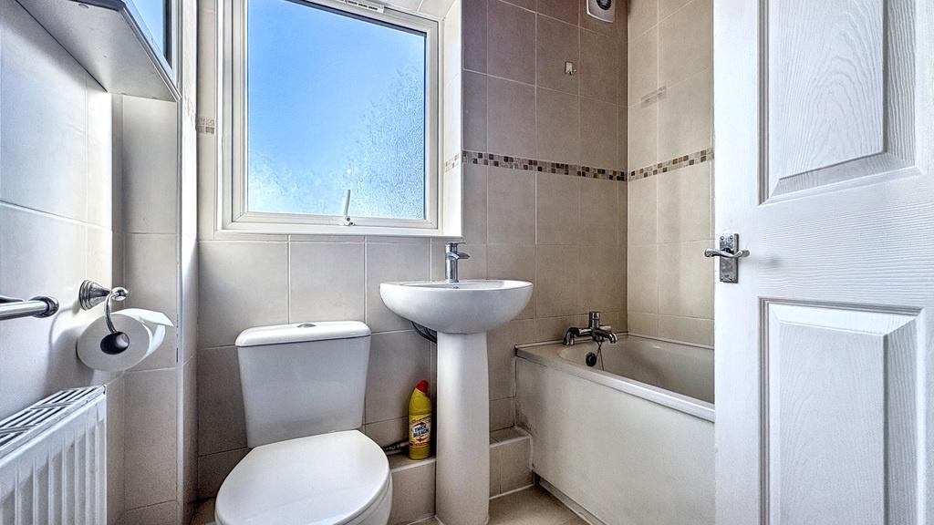 Bright, clean bathroom with a pedestal sink, to...