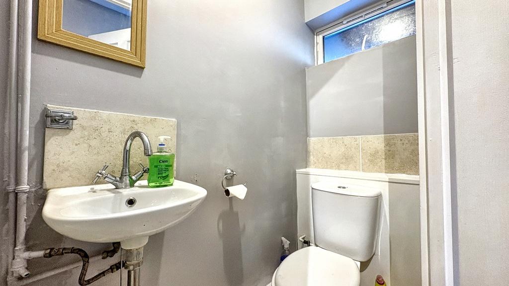 Neat, modern bathroom with a wall-mounted sink,...