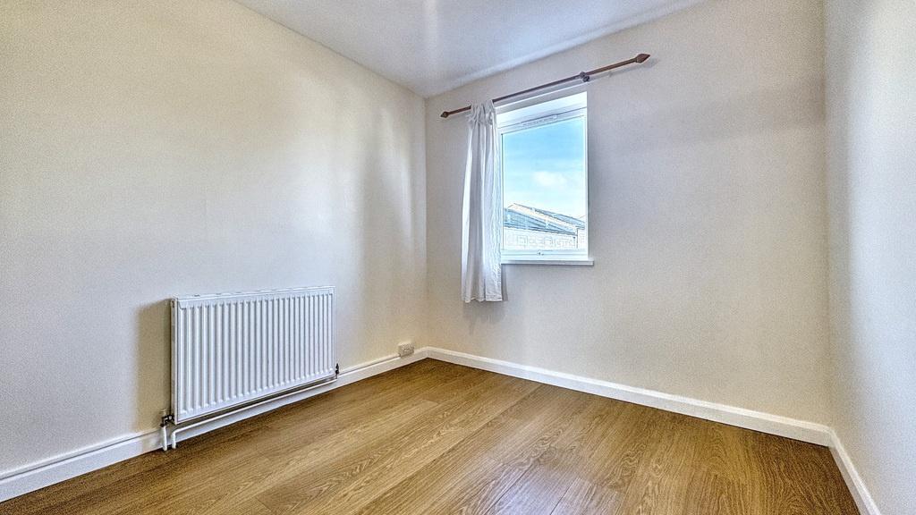 Bright, freshly painted single bedroom with war...