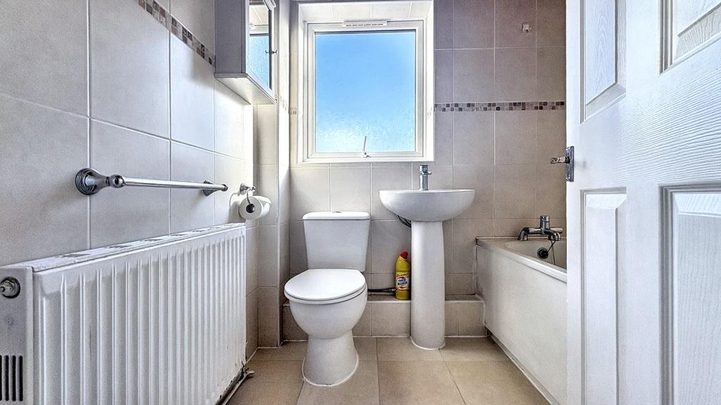Bright, clean bathroom with a white suite, pede...