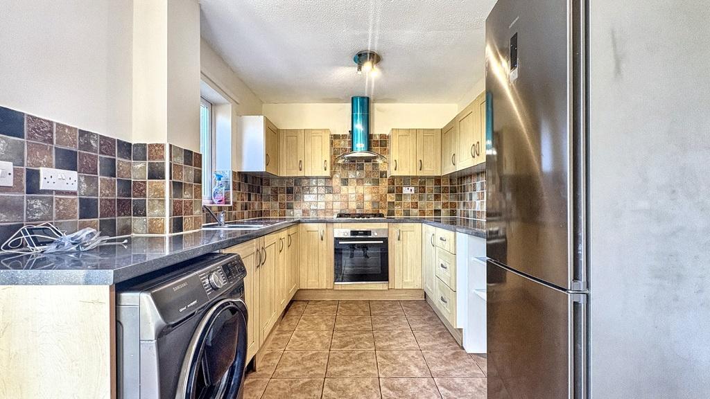 Modern galley-style kitchen with tiled floor, m...